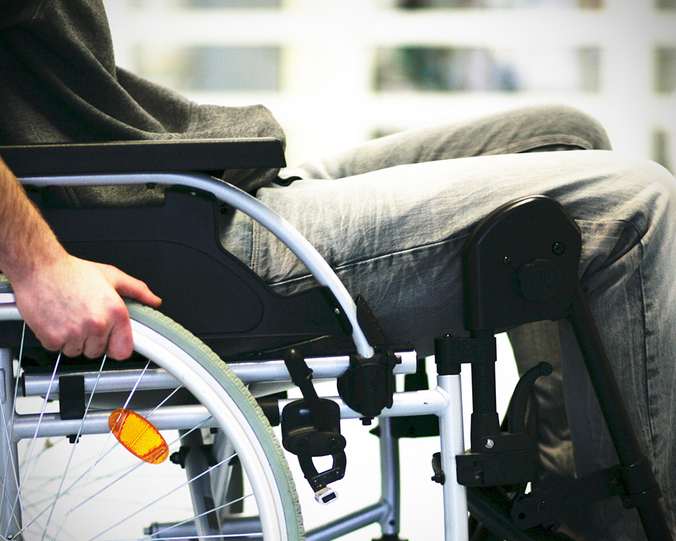 Una persona con diversidad funcional hace uso de una silla de ruedas para su desplazamiento
